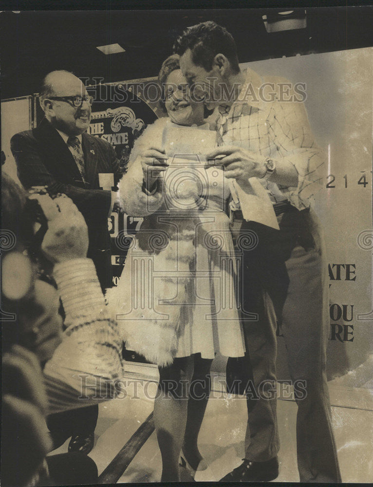 1975 Press Photo Bernard Lindsey hugs wife Betty holding check after winning lot - Historic Images