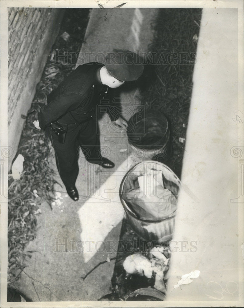 1937 Policeman from town hall station searches north side yards - Historic Images