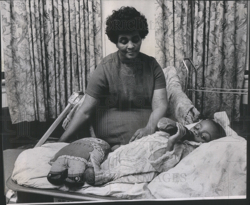 1971 Press Photo 2 year old Kelly with her mother Ernelle James Kelly suffering - Historic Images