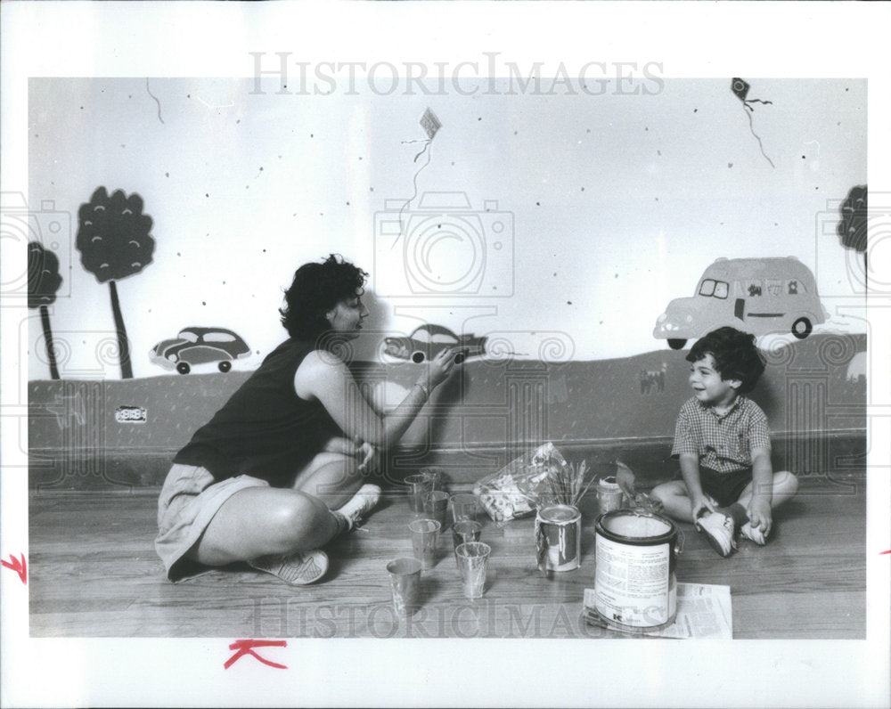 1990 Artist Judy with CodyRubin, as she paints his room. - Historic Images