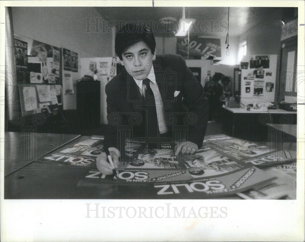 1984 Press Photo Attorney Juan M. Soliz Signs His Chicago Political Posters - Historic Images