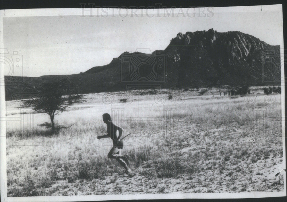 1983 Press Photo David Smith runs across a grassy plain near Naibor Keju - Historic Images