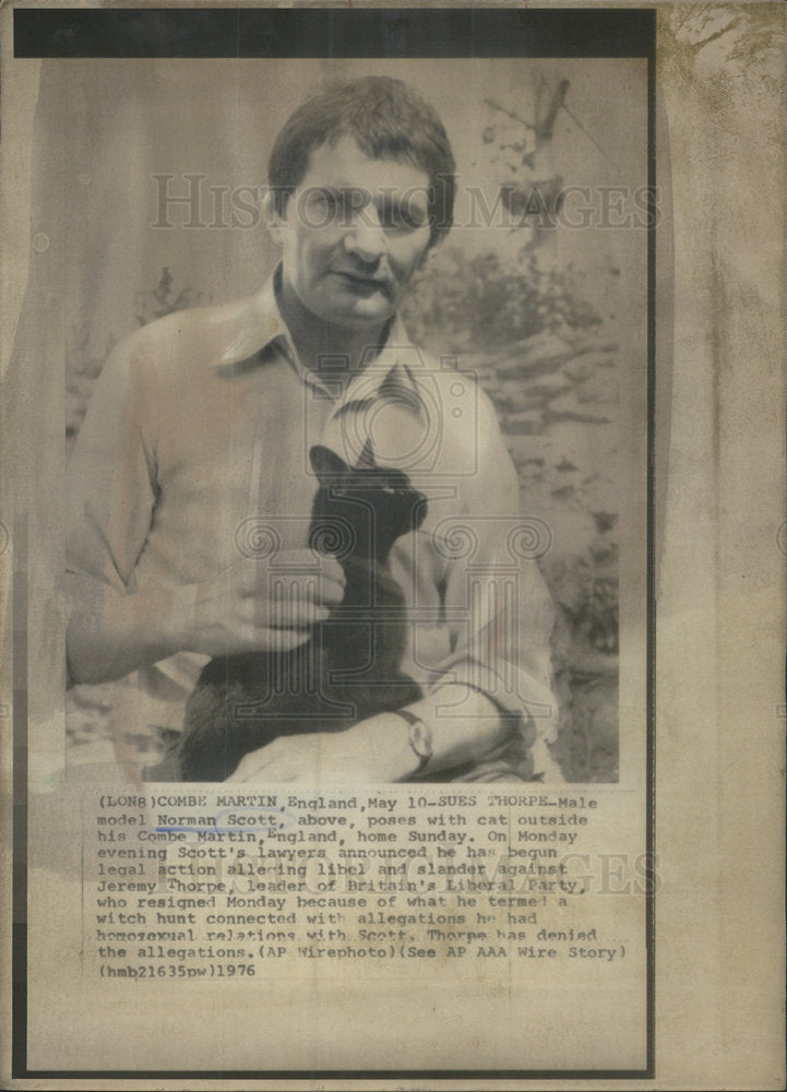 1976 Press Photo Male Model Norman Scott poses with cat outside Combe Martin, En - Historic Images