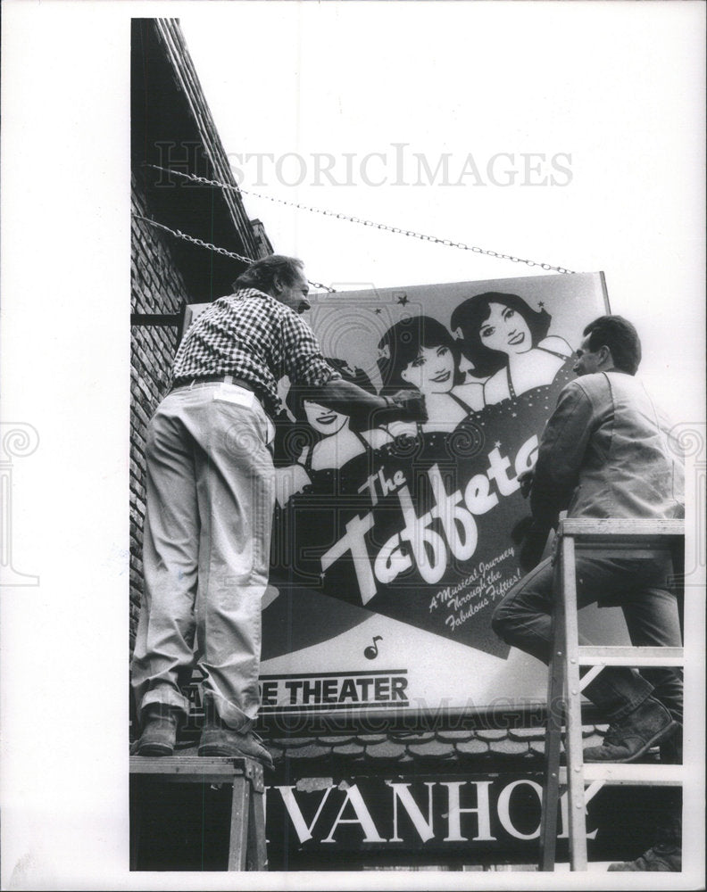 1989 Press Photo Larry Weintraub hangs the new sign for &quot;The Taffetas&quot; - Historic Images