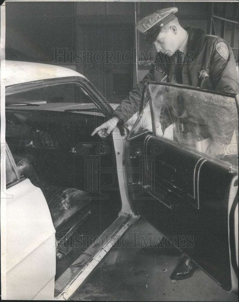 1965 Press Photo Policeman Charles Kemnitz inspects front seat of Ritter's car. - Historic Images
