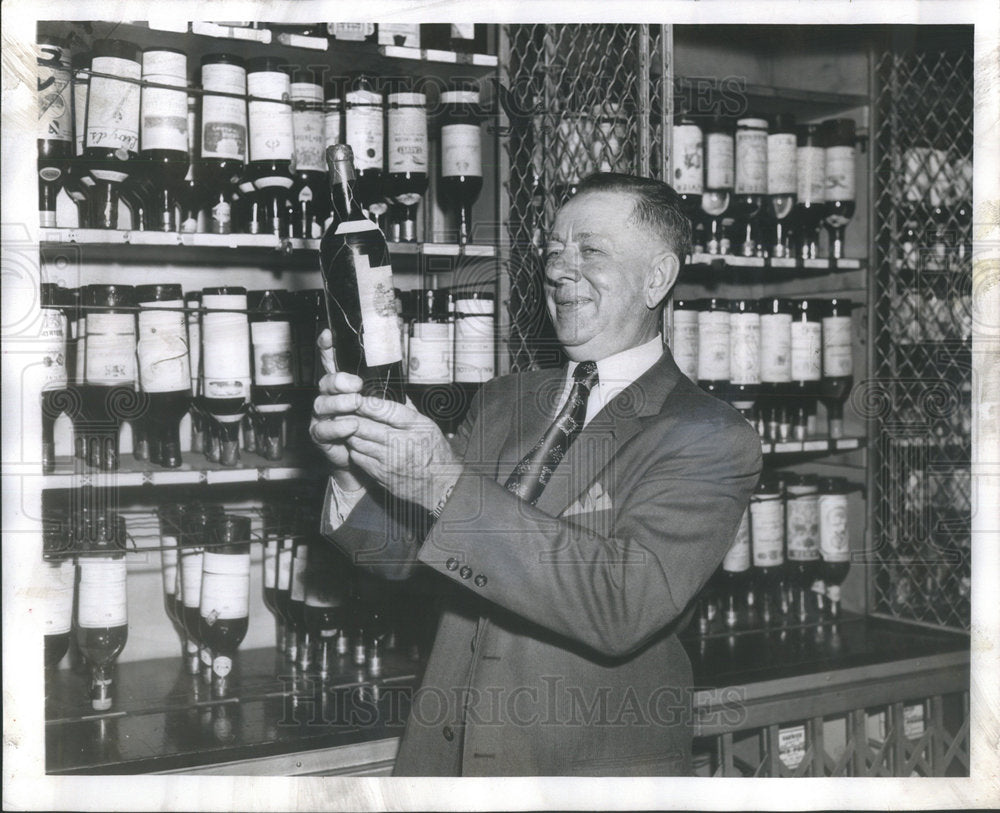 1956 Press Photo Restaurant Owner Teddy Majerus Checks His Wine Supply - Historic Images