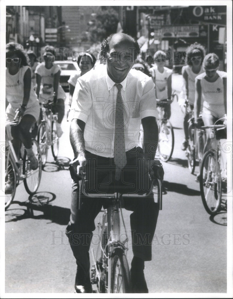 1985 Press Photo French Entrepreneur Derderian Riding Bike Promotional Stunt - Historic Images