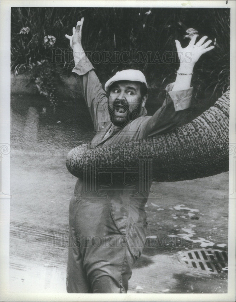 1982 Press Photo Dom DeLuise is surprised by a playful elephant. - Historic Images