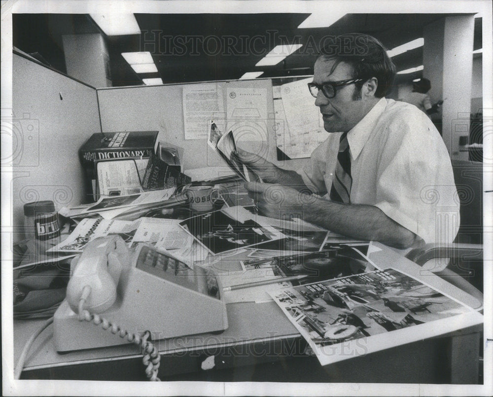 1975 Press Photo Victor Power Public Relations scans materials for one of the ma - Historic Images