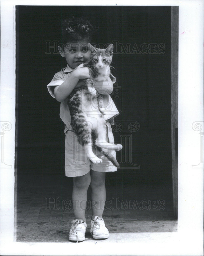 1989 Press Photo Isaac Santiago Lead Home by a Neighborhood Cat "Playboy" - Historic Images