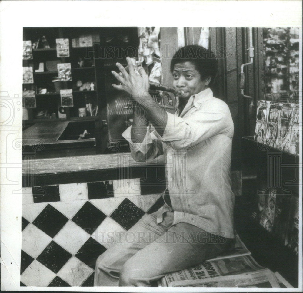 Press Photo Man Playing Trumpet Sitting On Newspapers Store - Historic Images