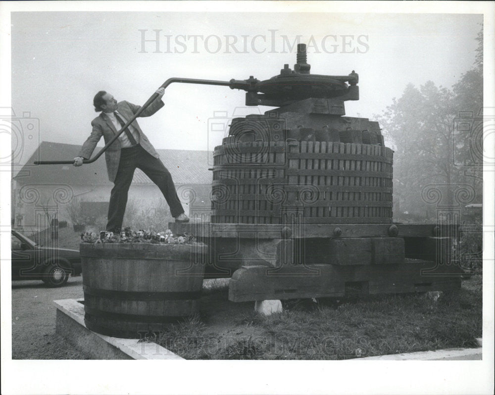 1989 Press Photo Larry Weintraub Cranks Antique Wine Press At French Winery. - Historic Images