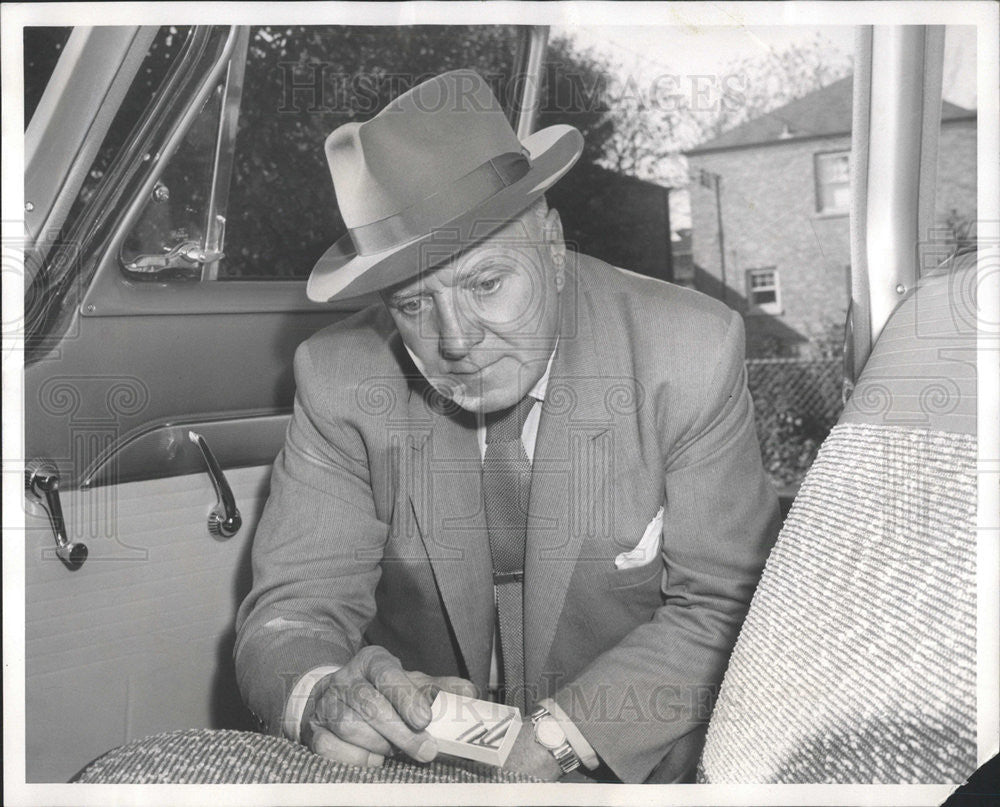 1958 Press Photo Policeman Elmer McAvoy looking at evidence - Historic Images