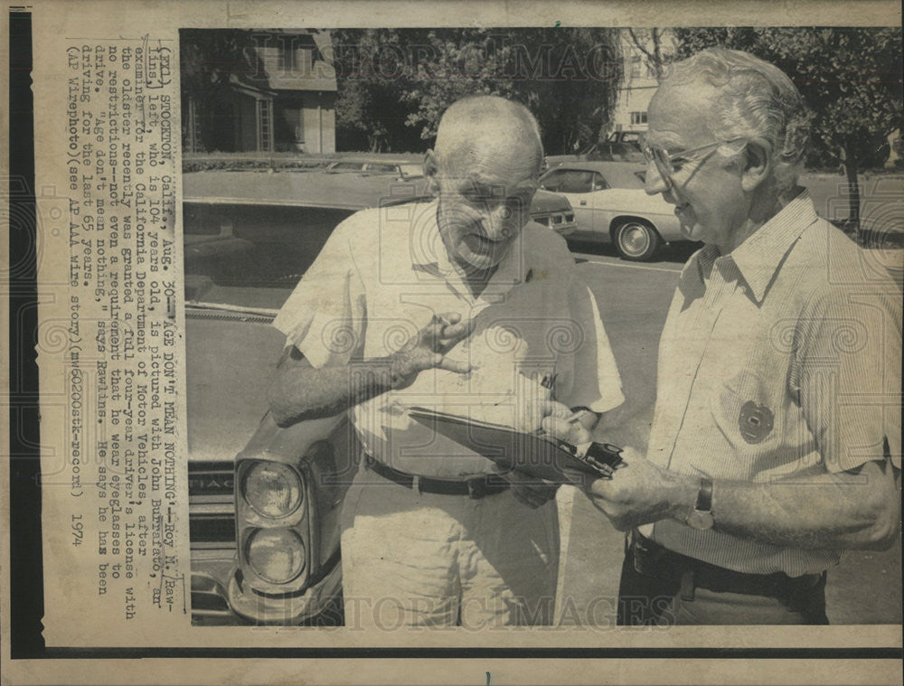 1974 Press Photo John Burrafato Examine 104 year Old Roy Rawlins Driving License - Historic Images