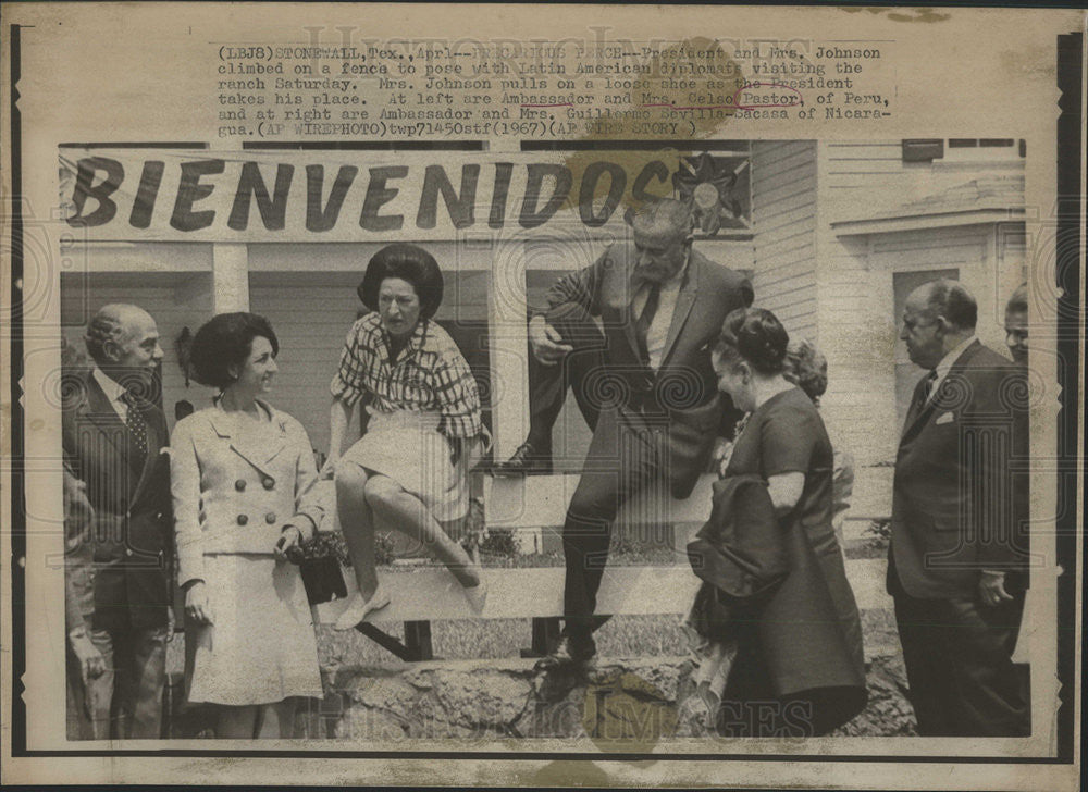 1967 Press Photo President Mrs. Johnson climb fence pose Latin American diplomat - Historic Images