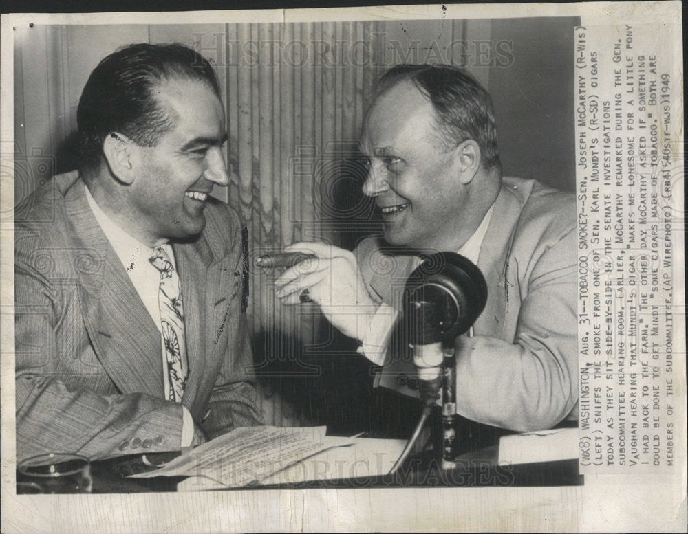 1949 Press Photo Joseph McCarthy Sniffs the smoke from one of Sen. Karl Mundt - Historic Images