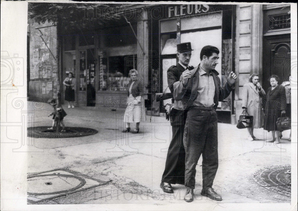 1958 Press Photo Gendarme searches a North African on a Parisan street - Historic Images