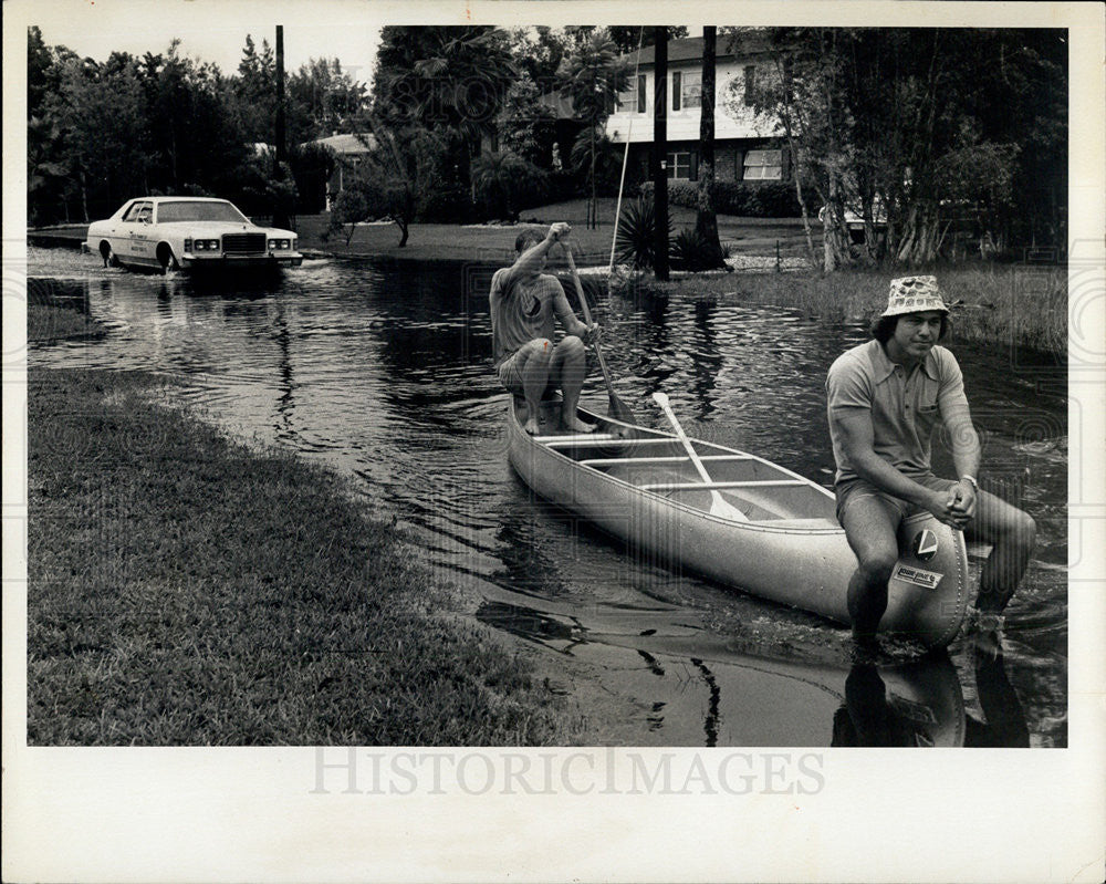1975 Press Photo F. Spirek and R. Hartic paddle thru hurricane flood waters - Historic Images