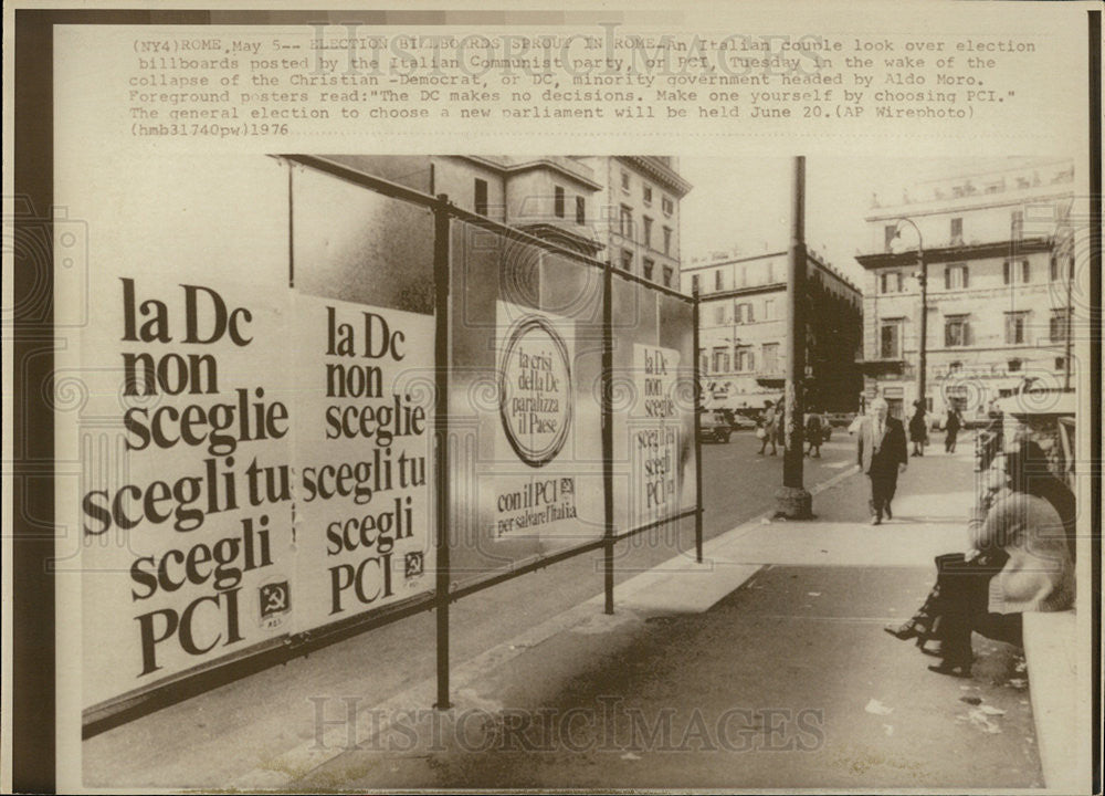 1976 Press Photo An Italian couple look over election billboards. - Historic Images