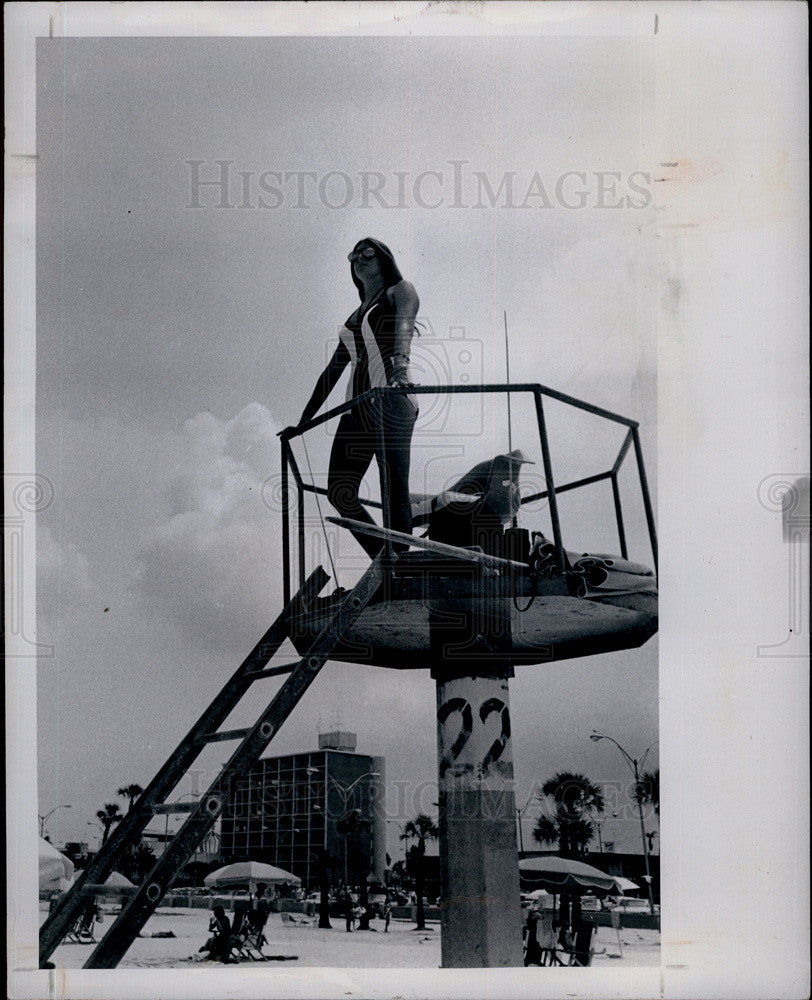 1975 Press Photo Pretty Lifeguard in Striped Swim Suit Standing on Beach Tower - Historic Images