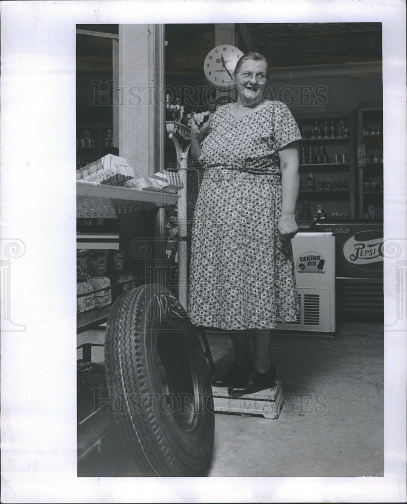 1958 Press Photo Woman standing on a scale in a basement - Historic Images