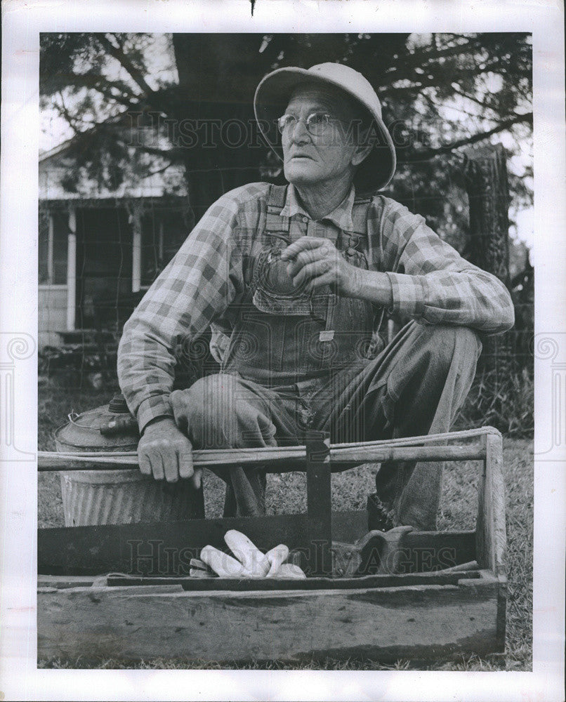 1958 Press Photo Farmer squatting down - Historic Images