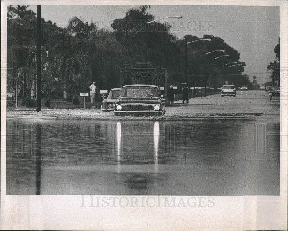 1965 Press Photo Cars Continue to Pass Flooded Streets - Historic Images