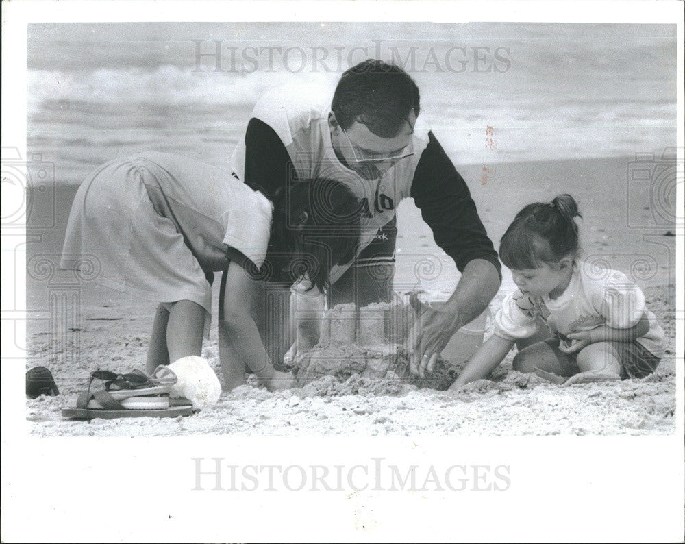 1987 Press Photo Kevin Anderson and kids Emily &amp; Stepanine build sandcastle Fla - Historic Images