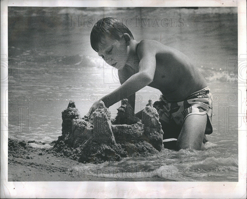 1977 Press Photo Gene Crittenden 10 builds sandcastle on beach - Historic Images