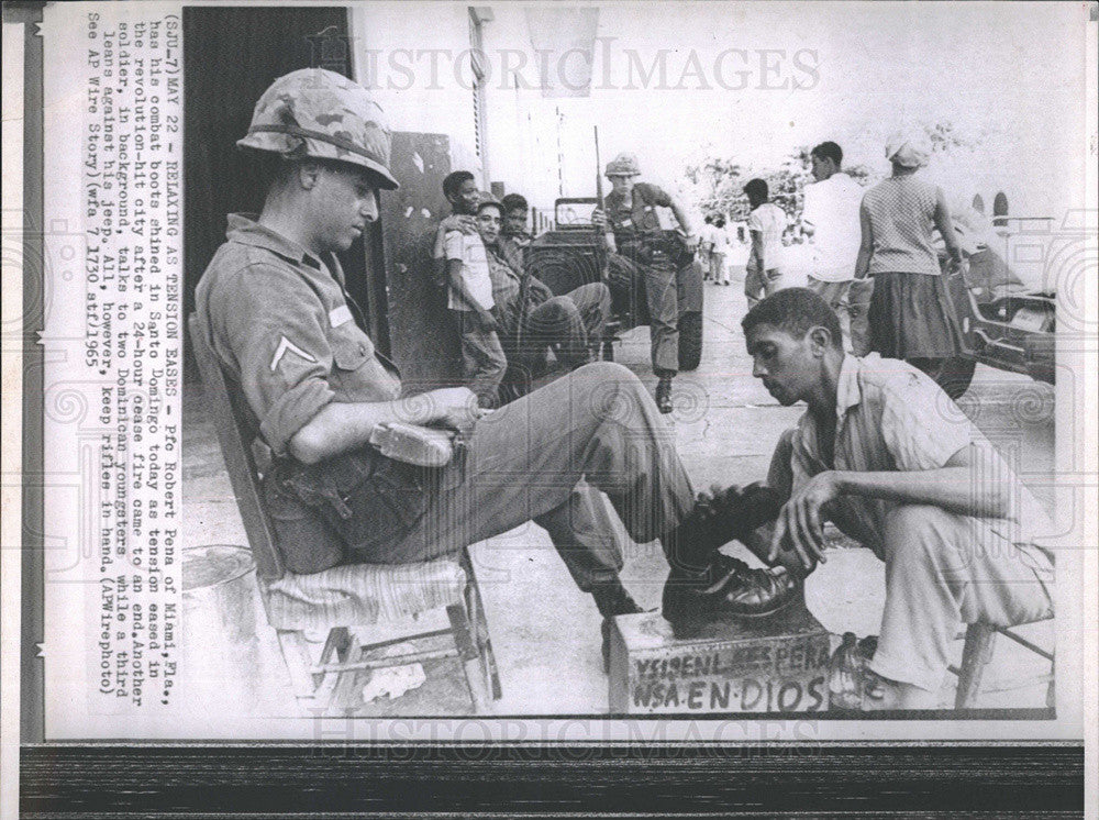 1965 Press Photo Robert Pena Gets  Boot Shine in Santo Domingo After Outbreak - Historic Images