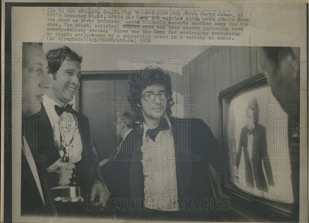 1976 Press Photo Chevy Chase Holds Emmy And Watches Loren Michaels Accept Emmy - Historic Images