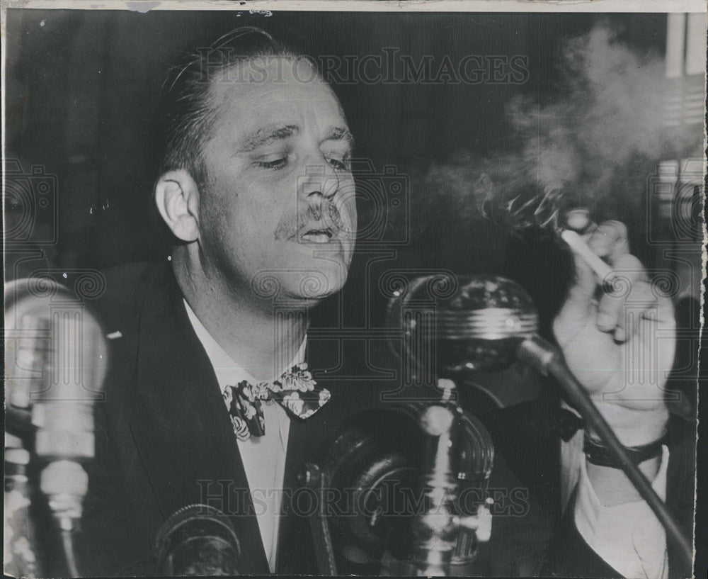 1947 Press Photo of Elliot Roosevelt blows a cloud smoke. - Historic Images