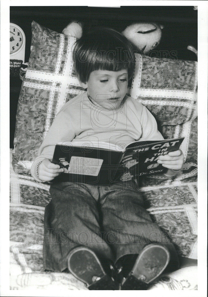 Press Photo A beginner reader enjoying The Cat in the Hat - Historic Images