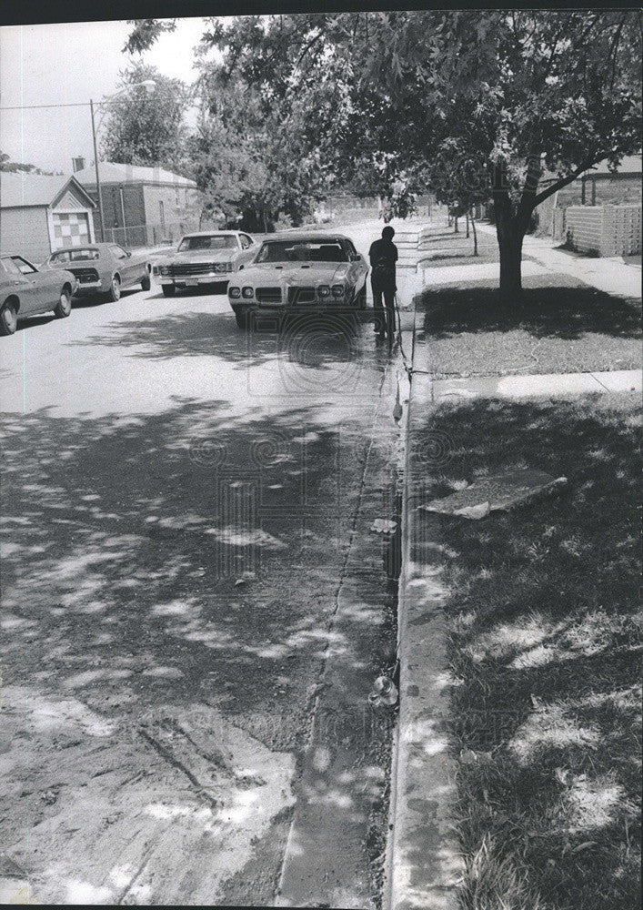 Press Photo Charles Bellis hoses curb at accident - Historic Images