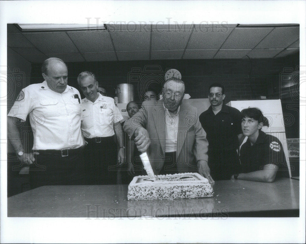 1994 Press Photo Charlie Thinger Cuts Cake For Engine Co. 108 For Saving Life - Historic Images