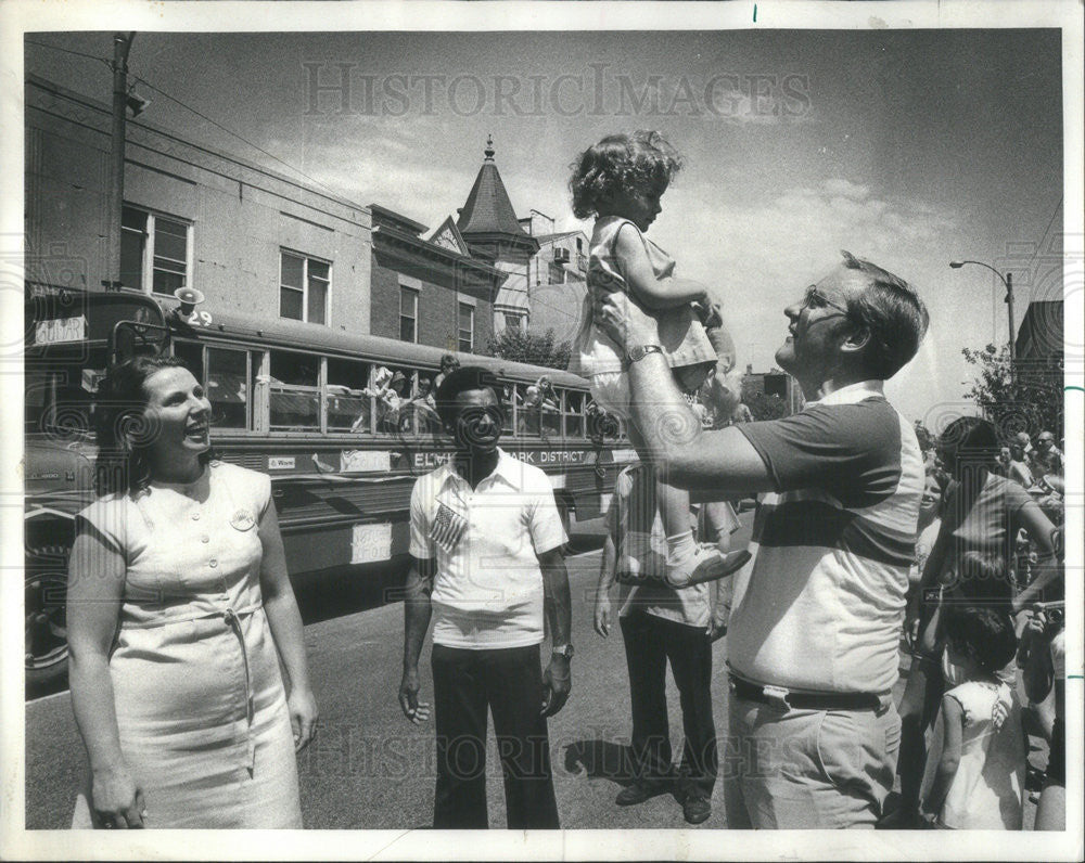 1977 Press Photo Gov Jim Thompson hoist spectator&#39;s child at Elmhurst 4th July parade - Historic Images