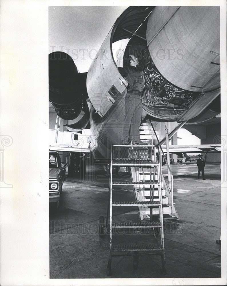 1976 Press Photo: Marshall Brunette works on engine. - Historic Images