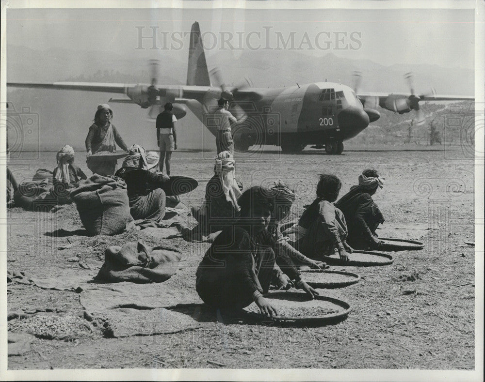 1973 Press Photo Hungry villager at Surkhei, Nepal sift grain brought Airlift. - Historic Images