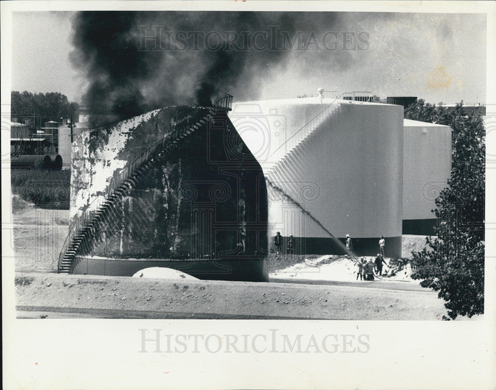 1987 Press Photo Firemen cool a smoldering fuel storage tank after an explosion - Historic Images