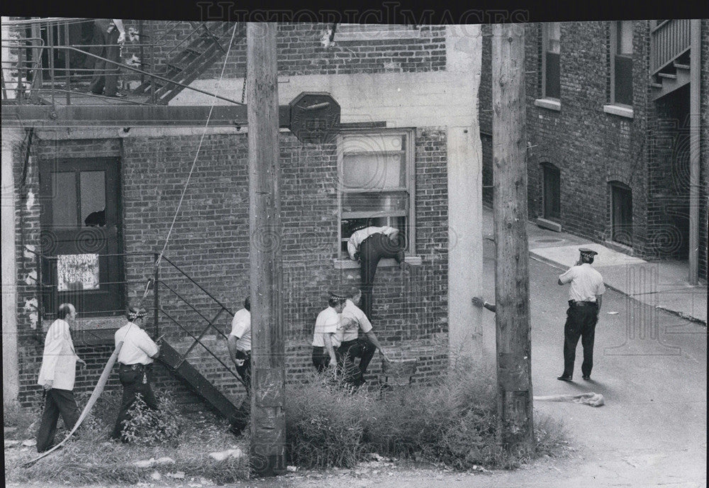 1976 Press Photo Police Climb through Kitchen Window of First Floor Apartment - Historic Images