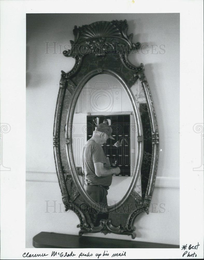 1992 Press Photo Clarence McGlade picks up his mail near the hotel lobby. - Historic Images