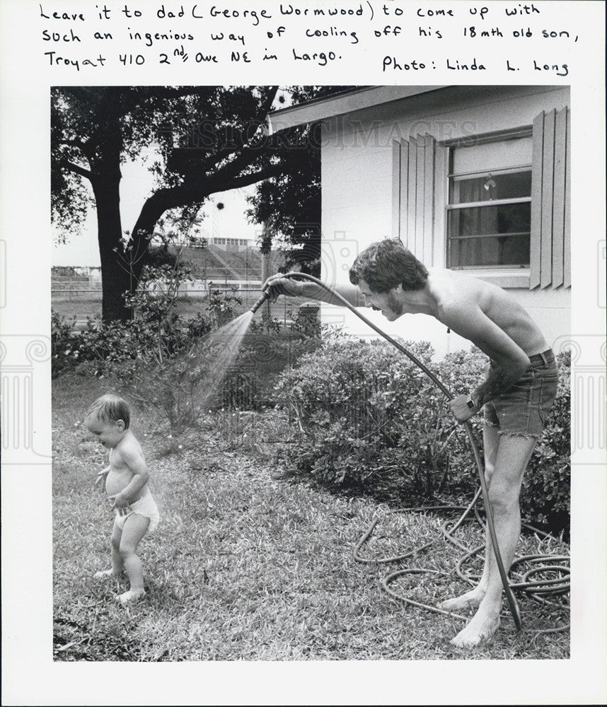 1986 Press Photo George Wormwood cooling off his son Troy from the summer heat - Historic Images