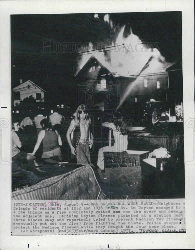 1977 Press Photo Neighbors try to save belongings from house on fire, while - Historic Images