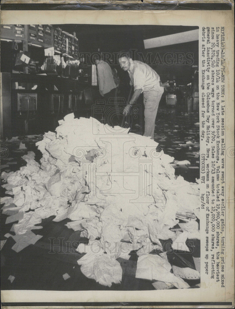 1975 Press Photo Workman on floor of New York Stock Exchange sweeps debris - Historic Images