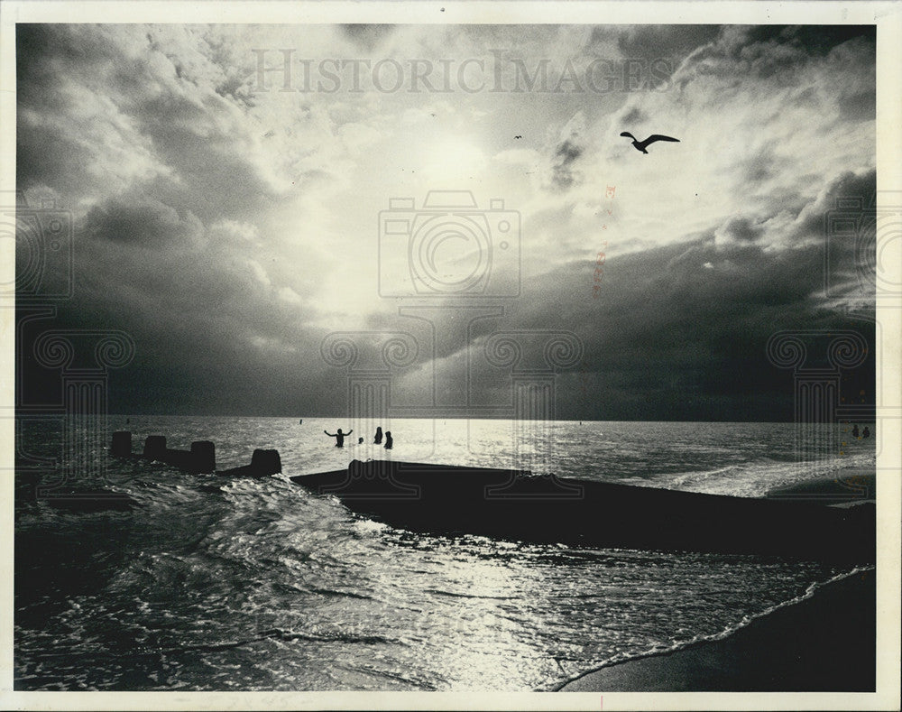 1991 Press Photo Swimmers Enjoy Sunset IN Madeira Beach Waters With Storm Clouds - Historic Images