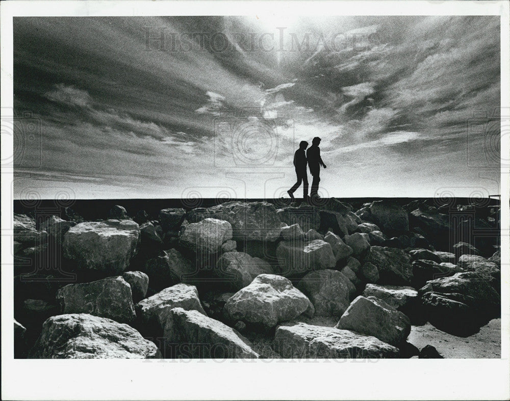 1987 Press Photo Two People Walk Pass-A-Grille Beach Jetty Florida - Historic Images