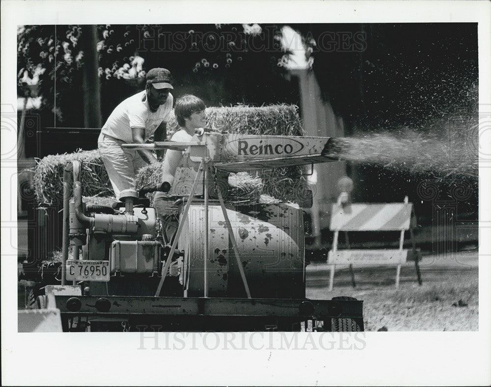 1983 Press Photo Scarborough Construction Workers Spray hay Orange Lake Banks - Historic Images