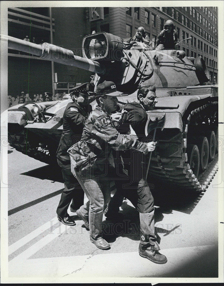 1986 Press Photo Man In Reagan Mask Jumps Onto Tank With Hatchet-Armed Forces - Historic Images