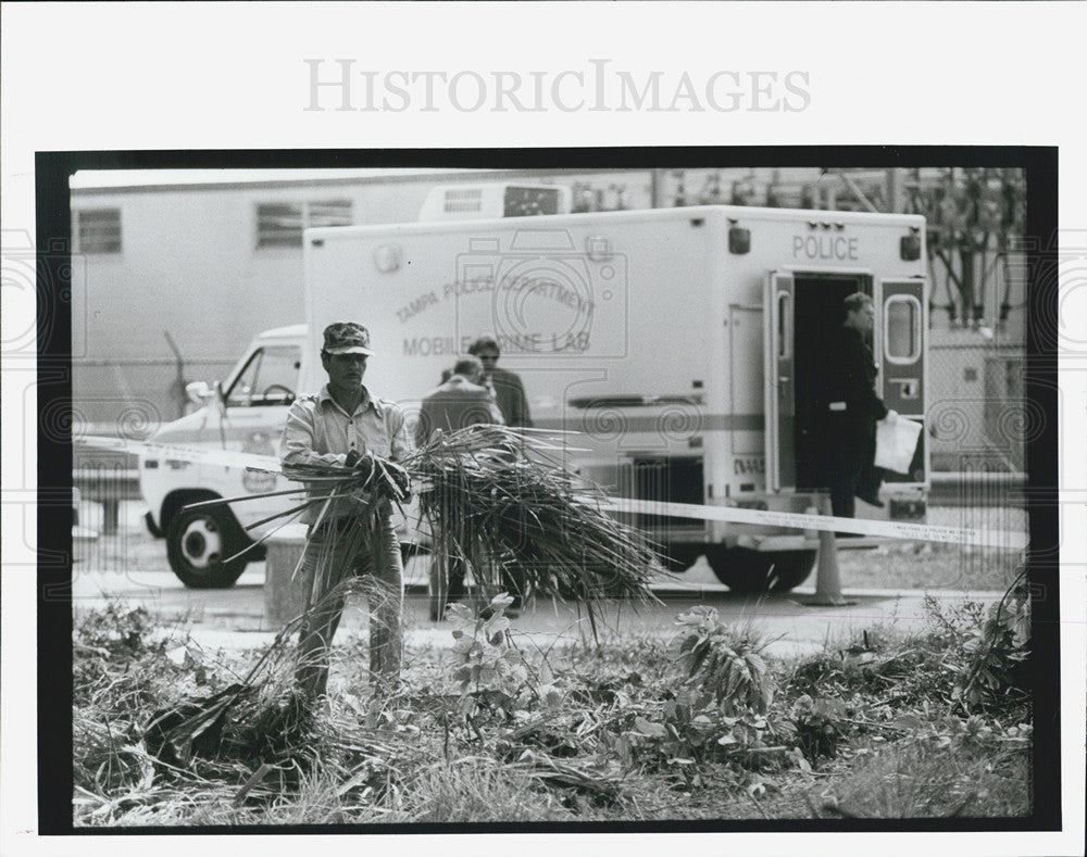 1992 Press Photo Roman Tobal cleans vacant lot stabbing victim was found in - Historic Images