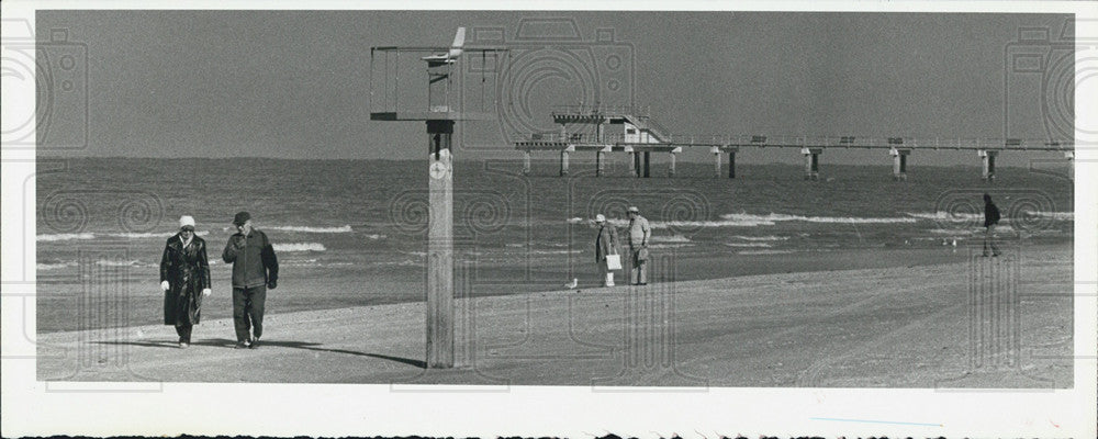 1981 Press Photo Brave Tourists Walk Along Cold Windy Beach - Historic Images